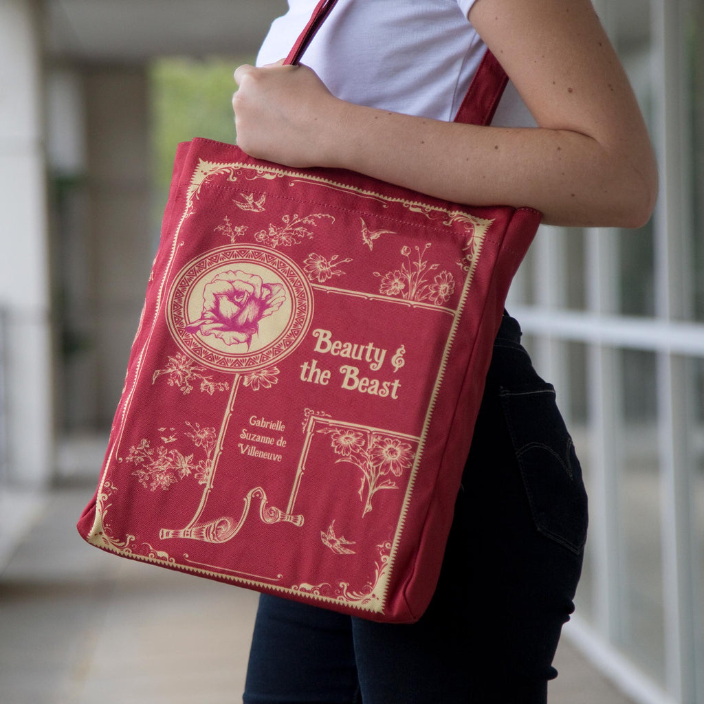 Beauty and the Beast Red Tote Bag by Gabrielle-Suzanne de Villeneuve featuring Gold Flowers and Swallows design, by Well Read Co. - Model With Bag