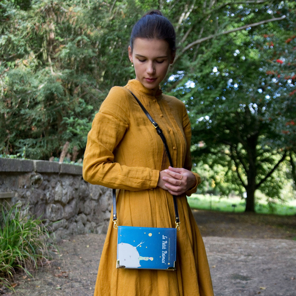 The Little Prince Blue Handbag by Antoine de Saint-Exupéry featuring Little Prince on his Home Planet design, by Well Read Co. - Model in Yellow Dress