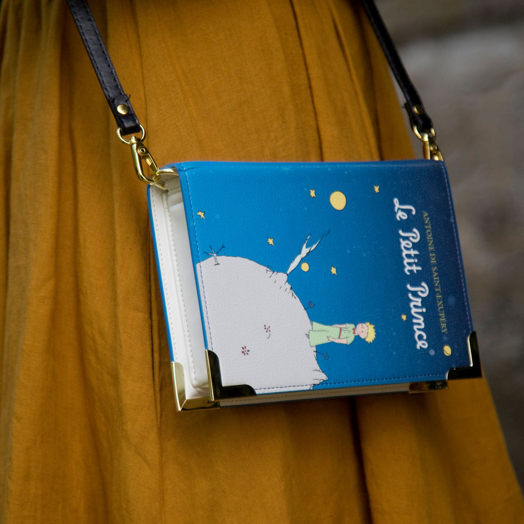 The Little Prince Blue Handbag by Antoine de Saint-Exupéry featuring Little Prince on his Home Planet design, by Well Read Co. - Model with bag